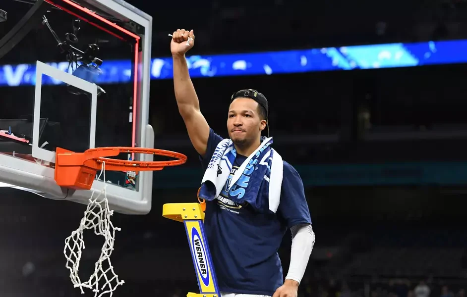 Villanova guard Jalen Brunson cuts down the net after winning the 2018 NCAA Championship. Image courtesy of Villanova athletics.