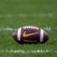 Stock image of a football on grass.